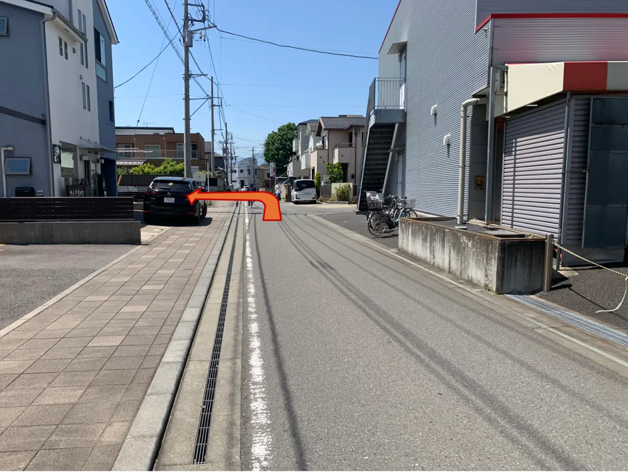 この道路は一方通行です。建物の奥へ進むと、左手に専用駐車場が見えます。
